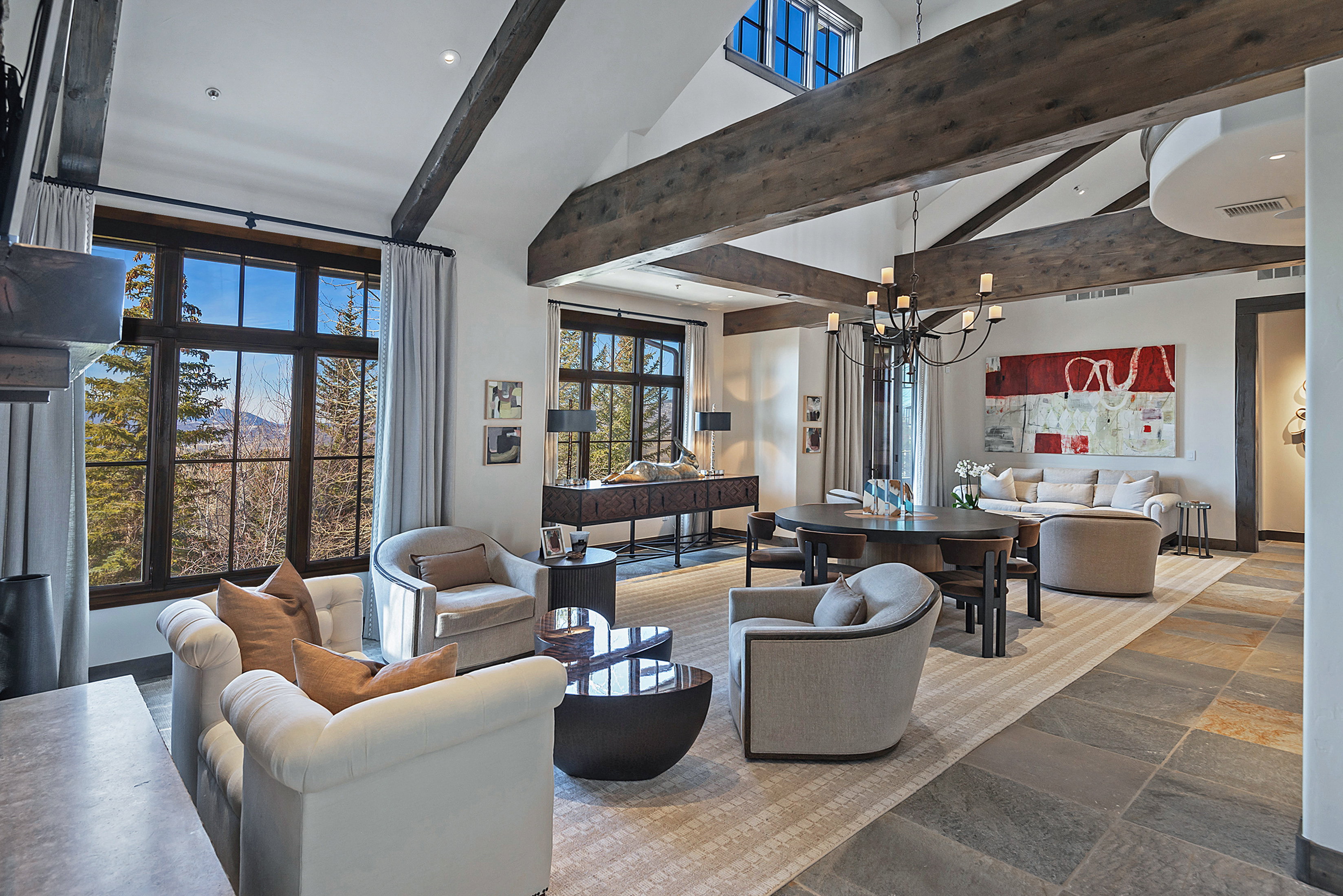Living area featuring stone tile flooring, vaulted ceiling, and suspended lighting