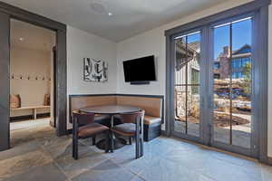 Dining area featuring stone tile flooring and baseboards