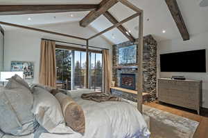 Bedroom with hardwood / wood-style floors, access to exterior, a stone fireplace, and recessed lighting