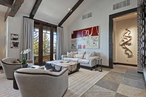 Living room with light stone finish floors, vaulted ceiling, and recessed lighting