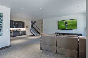 Living room with carpet, a dry bar, beverage cooler, and recessed lighting