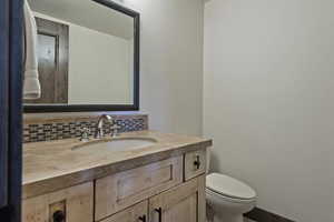 Half bathroom with vanity and tasteful backsplash