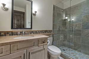 Bathroom with vanity, a stall shower, tile walls, and wainscoting