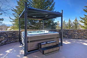 View of patio with a hot tub