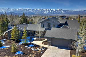 View of front of property featuring stone siding, board and batten siding, driveway, and a mountain view