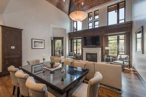 Dining room featuring dark wood finished floors, a fireplace, and vaulted ceiling