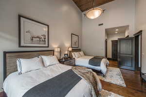 Bedroom featuring dark wood finished floors and vaulted ceiling