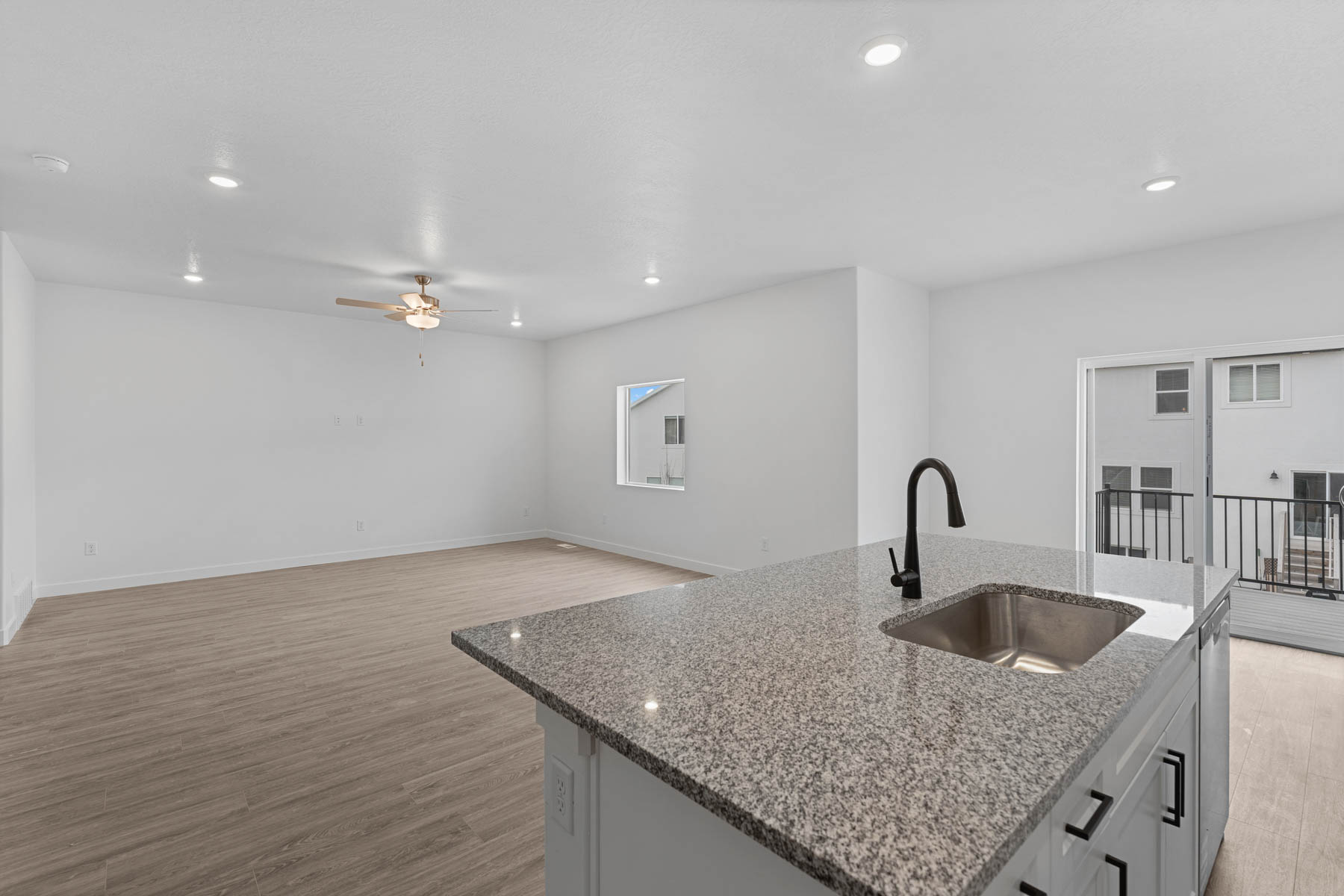 Kitchen island featuring a granite countertop with an undermount sink and matte black faucet