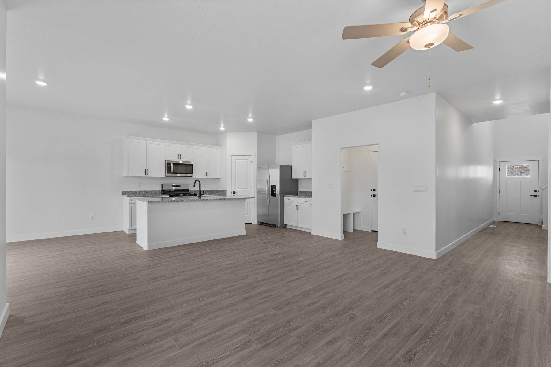 Open-concept main living space featuring wood-finish flooring, recessed lighting, and a contemporary ceiling fan