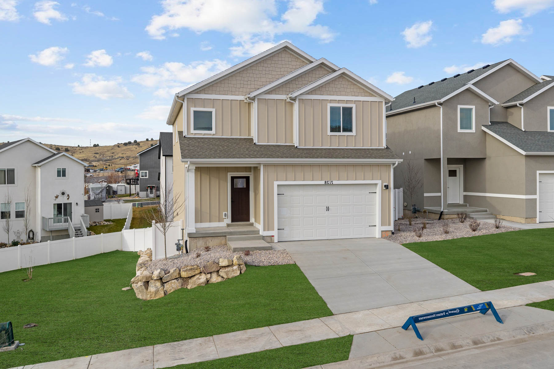Contemporary two-story residence featuring a two-tone facade, attached garage, and a concrete driveway
