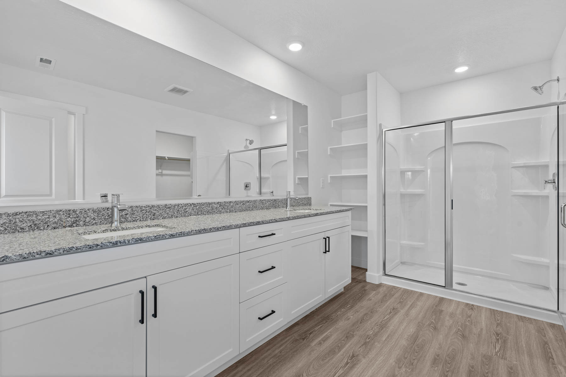 Dual sink vanity with granite countertop and integrated sinks, complemented by contemporary matte black hardware