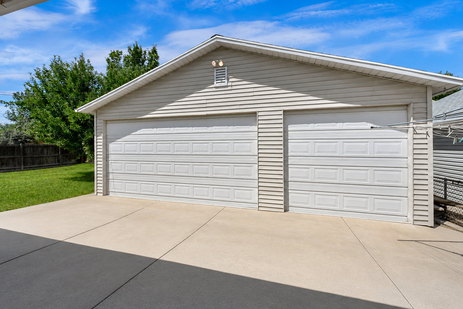 Detached garage with two white panel garage doors