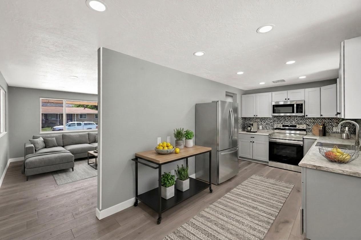 Modern kitchen featuring light gray cabinetry, and light-toned countertops. Virtually staged to illustrate the home's potential.