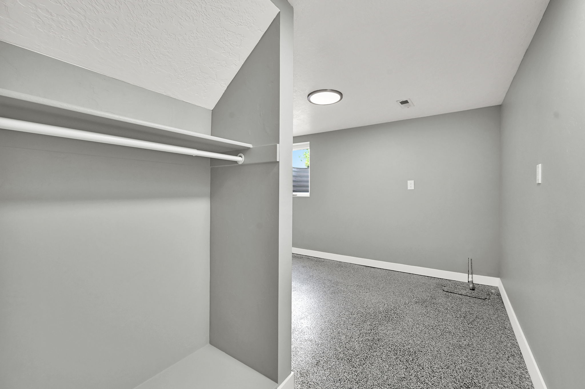 Bedroom with recessed closet featuring a hanging rod and shelving.