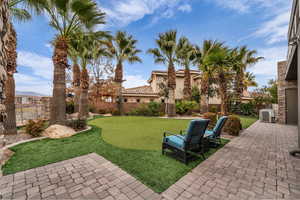 Fenced backyard featuring a patio area and an area to practice putting
