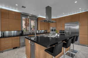 Kitchen featuring a kitchen bar, stainless steel appliances, modern cabinets, island range hood, and recessed lighting