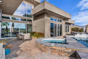 Relaxing pool / spa with a patio and outdoor dining space