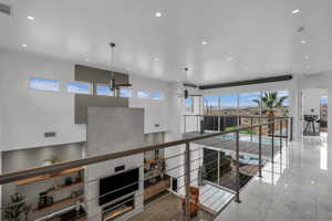 Hallway with recessed lighting and a high ceiling