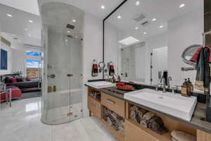 Bathroom featuring double vanity, a marble finish shower, connected bathroom, and recessed lighting