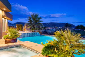Outdoor pool featuring a mountain view, an in-ground hot tub, and a patio area