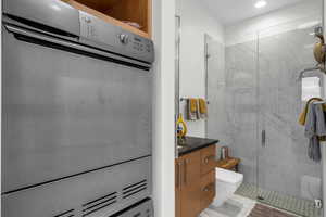 Full bath featuring a marble finish shower, vanity, and recessed lighting