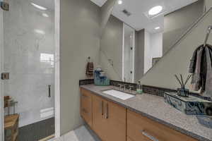 Full bathroom featuring a shower stall, vanity, and recessed lighting