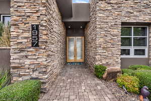 View of exterior entry featuring stone siding and stucco siding