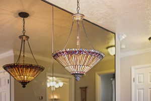 Detailed view of crown molding, full mirror and stainless glass light fixture