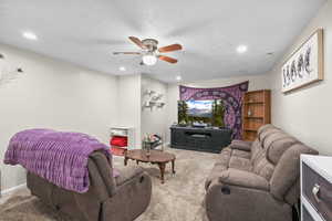 carpet flooring, a ceiling fan, a textured ceiling, and recessed lighting