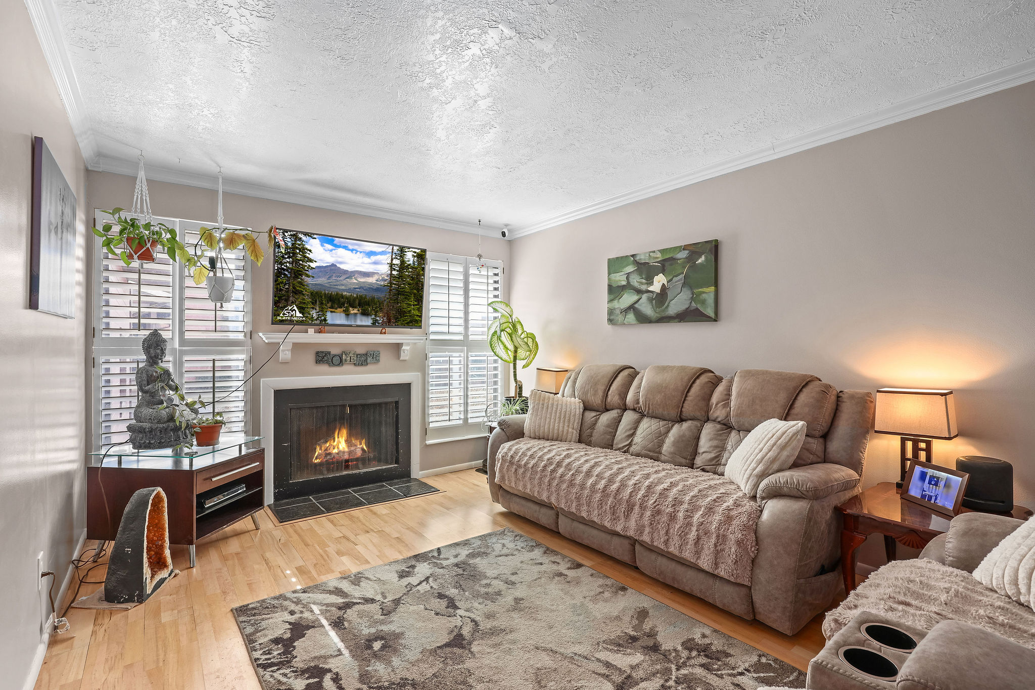 light wood finished floors, a fireplace with flush hearth, crown molding,, shutters, lots of light