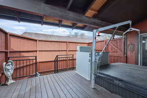Wooden terrace featuring a covered hot tub