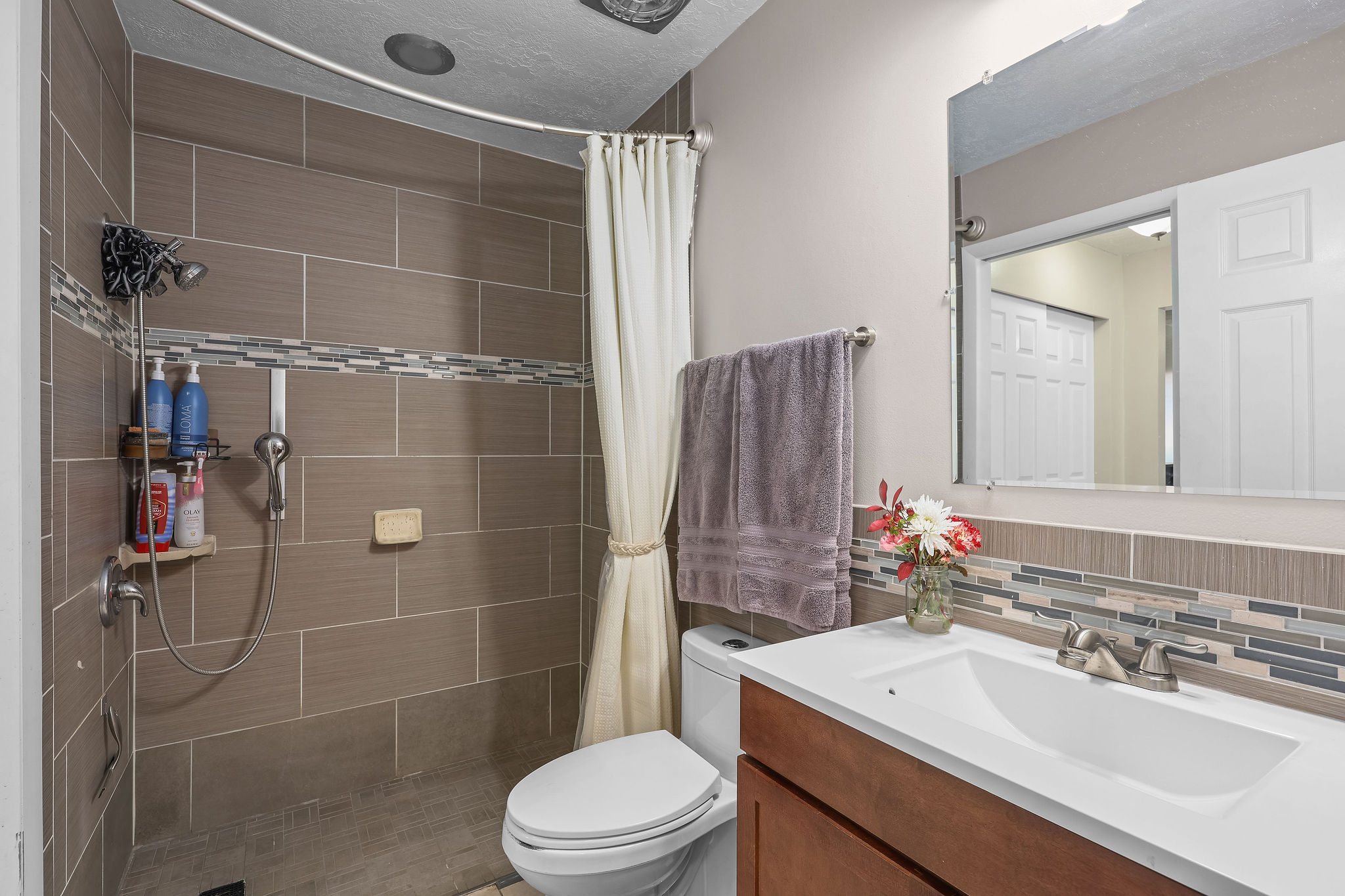 Bathroom featuring a roll in  shower and vanity