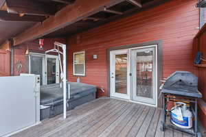 Wooden terrace featuring grilling area and a hot tub