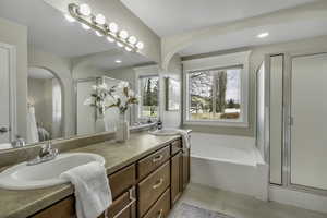 Bathroom featuring a stall shower, double vanity, a garden tub, recessed lighting, and light tile patterned floors