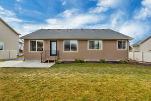 Rear view of house featuring stucco siding, a shingled roof, and a patio area
