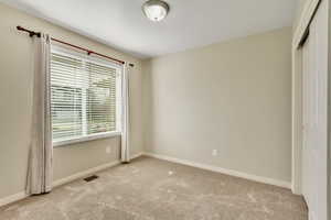 Unfurnished bedroom with light colored carpet and a closet