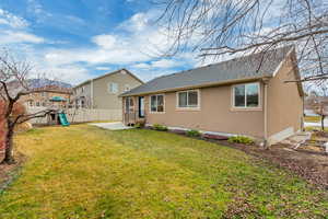 Back of property with roof with shingles, a patio area, stucco siding, and a playground