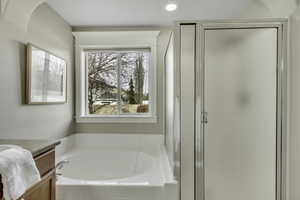 Bathroom featuring a stall shower, a bath, vanity, and recessed lighting