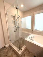 Bathroom featuring a garden tub, a stall shower, and a textured ceiling