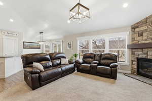 Living area featuring lofted ceiling, recessed lighting, a fireplace, and wood finished floors