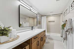 Full bathroom featuring shower / bath combo with shower curtain and vanity
