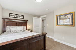 Bedroom featuring light carpet and baseboards