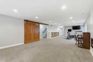 Workout room with a barn door, recessed lighting, and light carpet