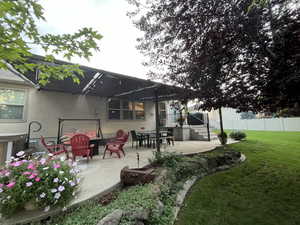Rear view of property featuring a patio area, stucco siding, and outdoor dining space