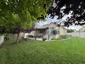 Back of house featuring a gate, solar panels, a fenced backyard, a patio, and stucco siding