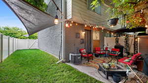 View of property exterior with a fenced backyard, a patio, brick siding, and outdoor lounge area