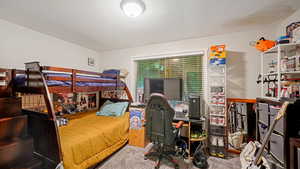 Carpeted bedroom with a desk