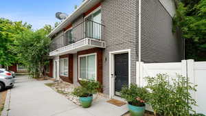 View of side of property with brick siding and a balcony