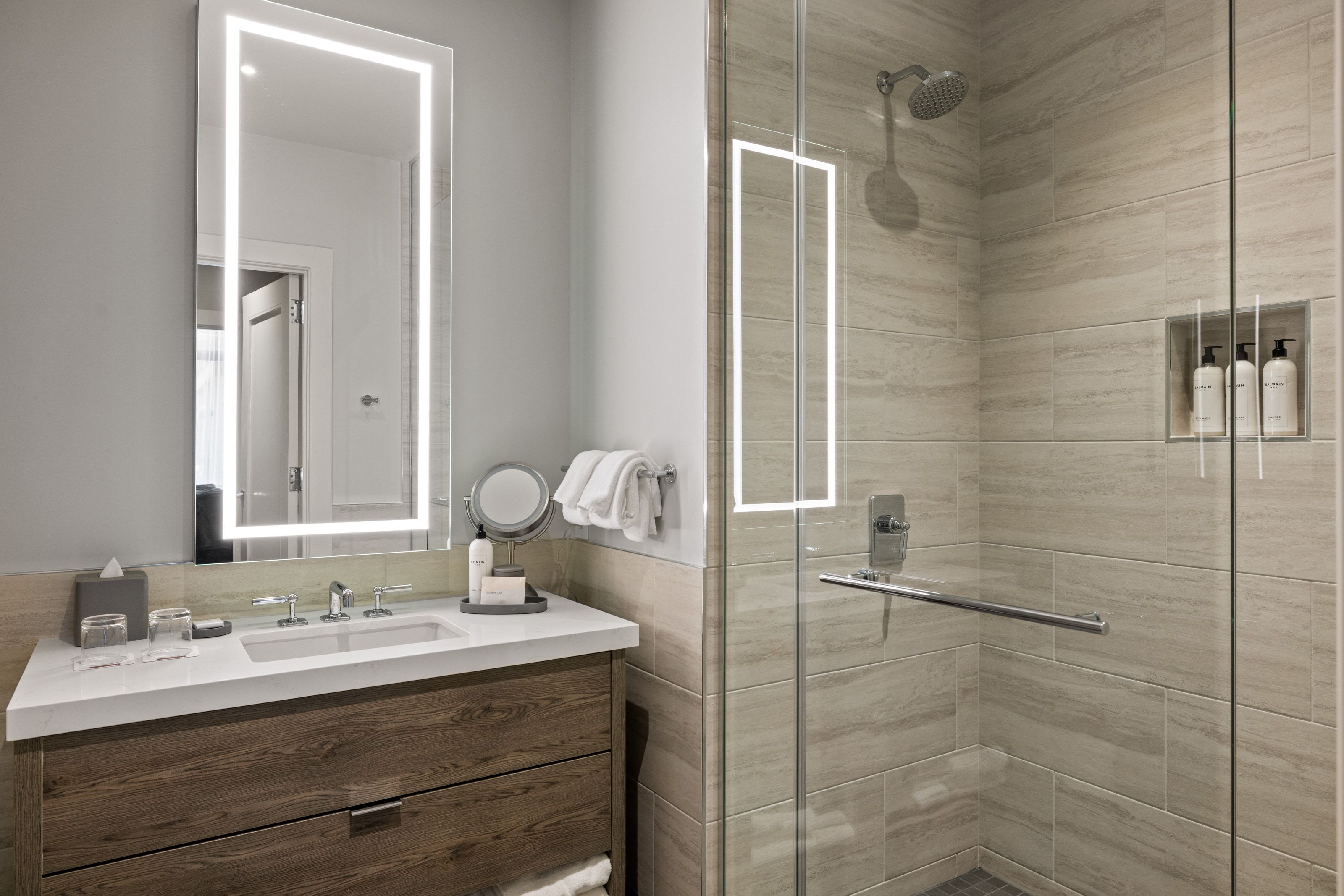 Bathroom with vanity, a shower stall, tile walls, and wainscoting