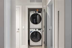 Laundry area with stacked washer / dryer and tile patterned floors